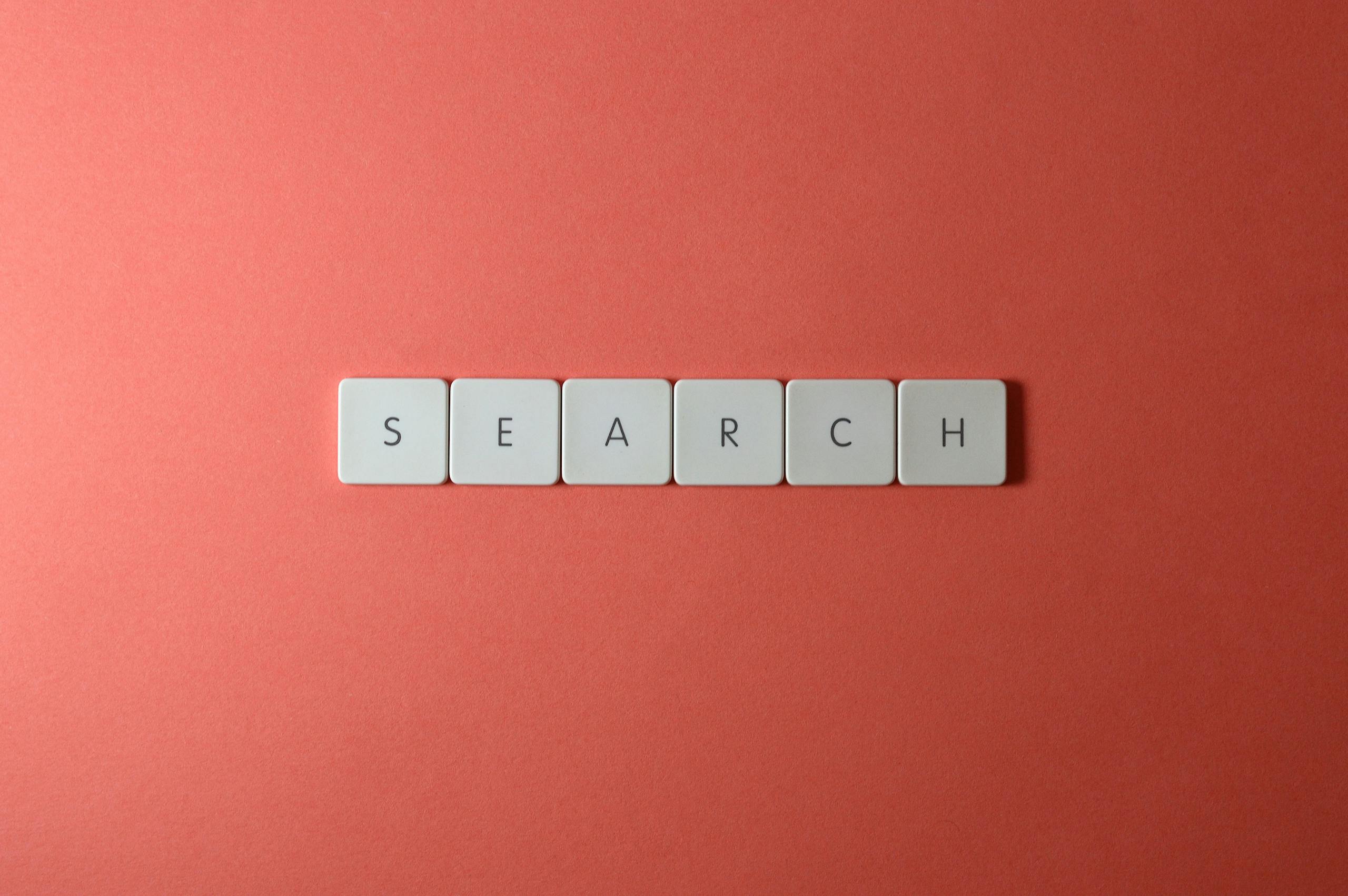 White keyboard keys spelling 'search' on a bold red surface, conceptual design with copyspace.
